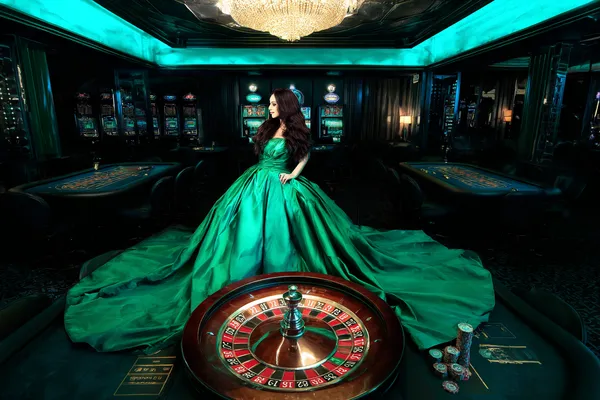 A woman in a luxurious green gown next to an ornate roulette wheel, capturing the upscale casino mood of BDTJL.